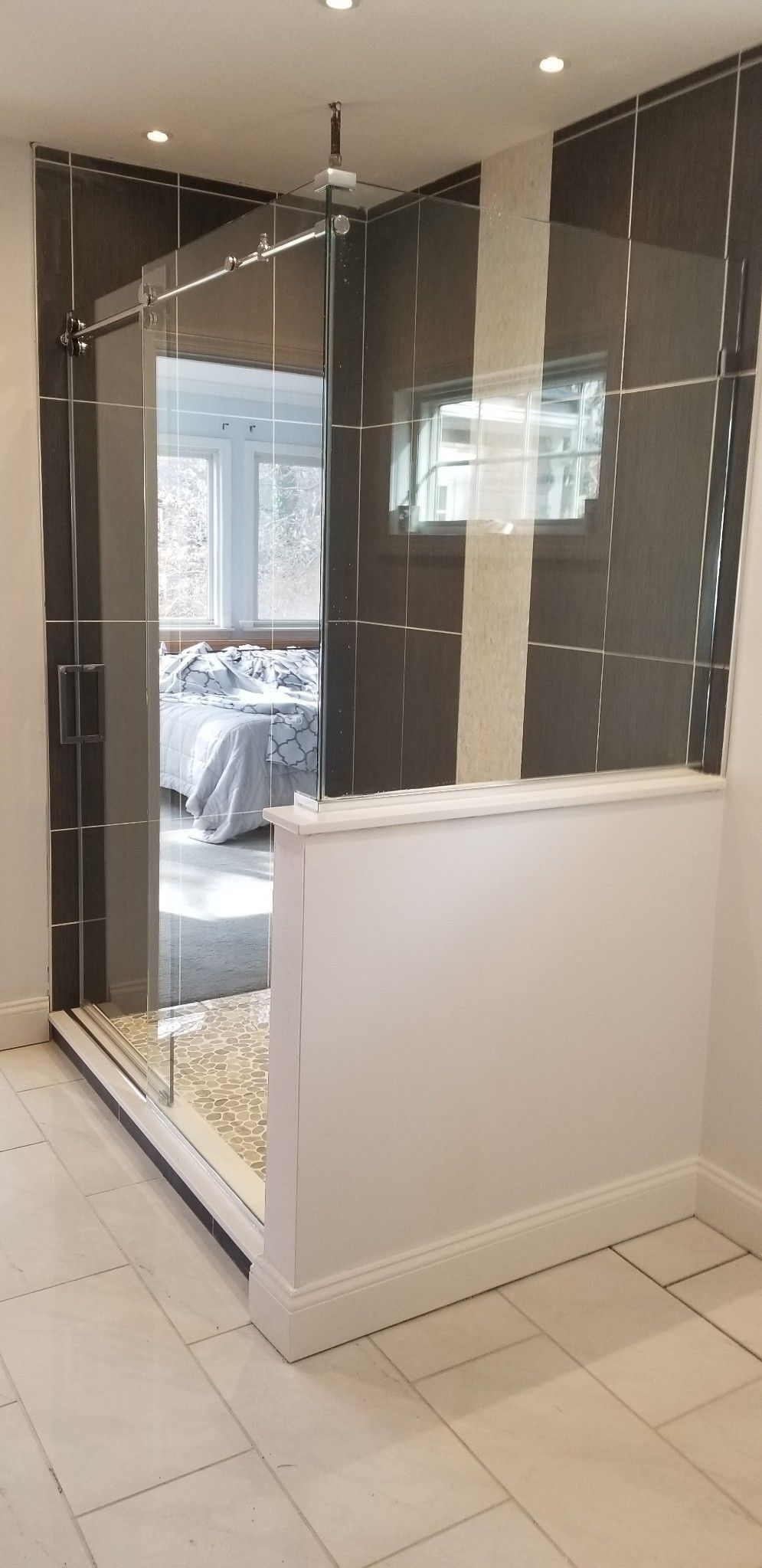 A bathroom with a walk in shower and a large mirror.