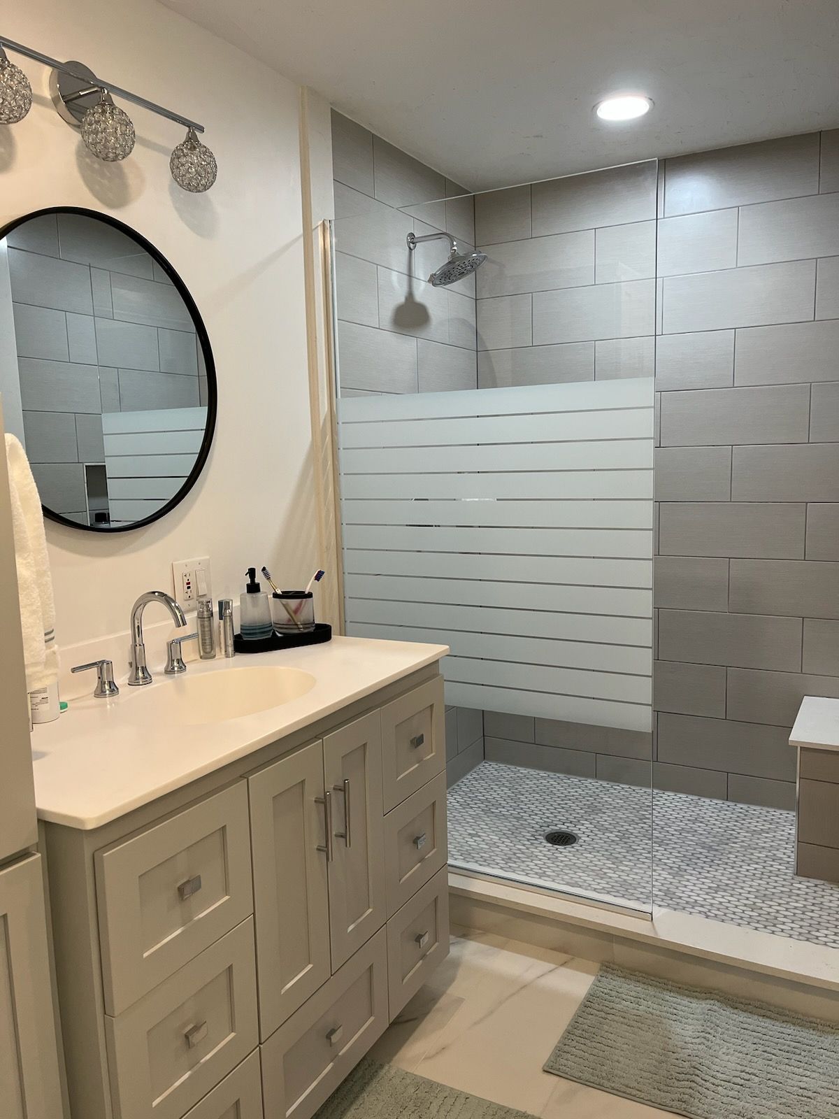 A bathroom with a sink , mirror , and shower.