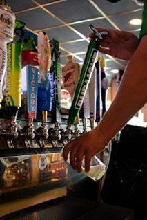 Bartender pouring beer from a Bud Light tap into a glass.