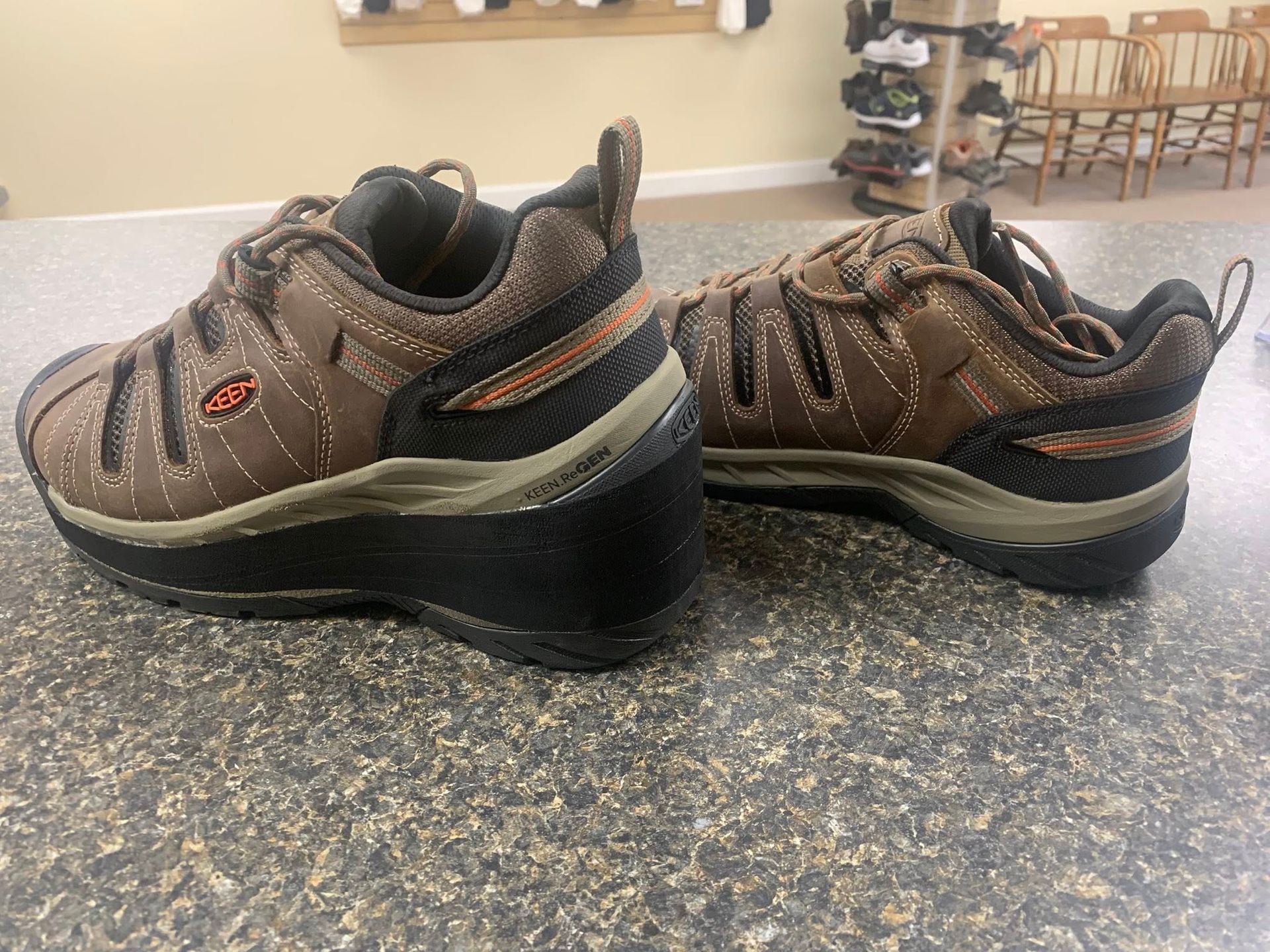 Brown and black Keen work shoes on a speckled countertop.