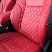 A close up of a red leather seat in a car