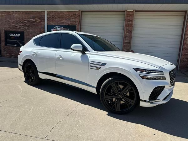 A white car is parked in front of a garage