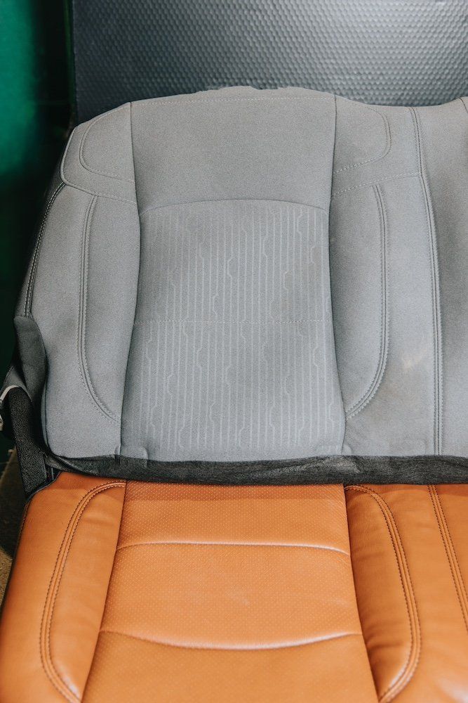 A close up of a car seat with a gray seat cover and a brown seat cover.