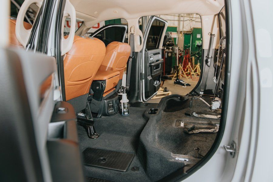 The inside of a car is being worked on in a garage.