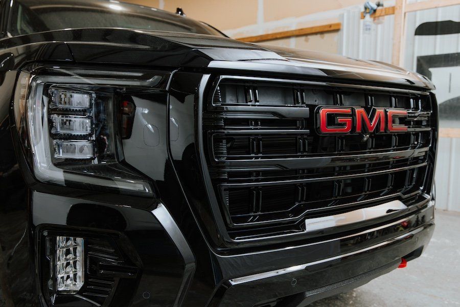 A black gmc truck is parked in a garage.