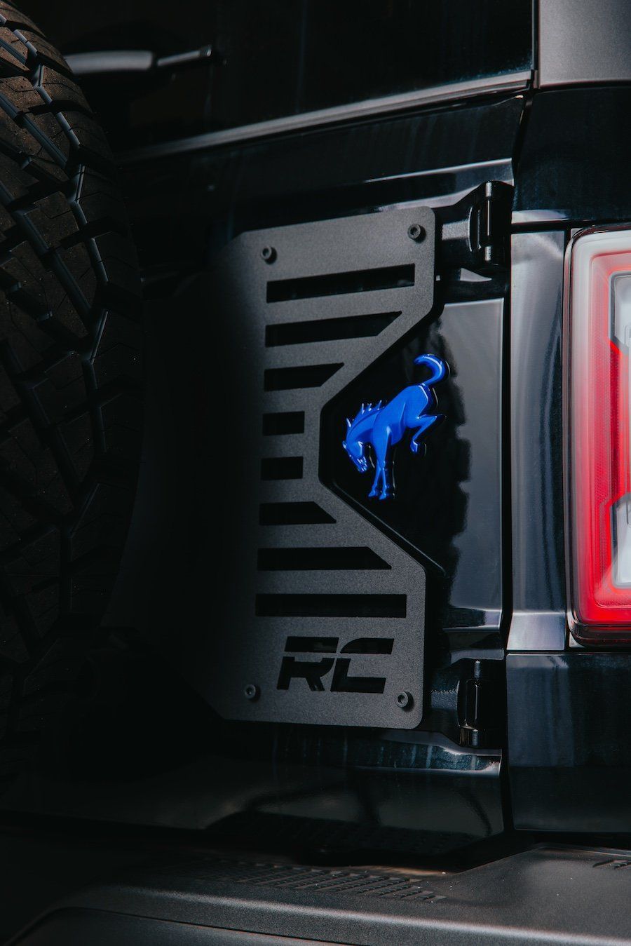 A close up of the back of a ford bronco with a blue emblem on it.