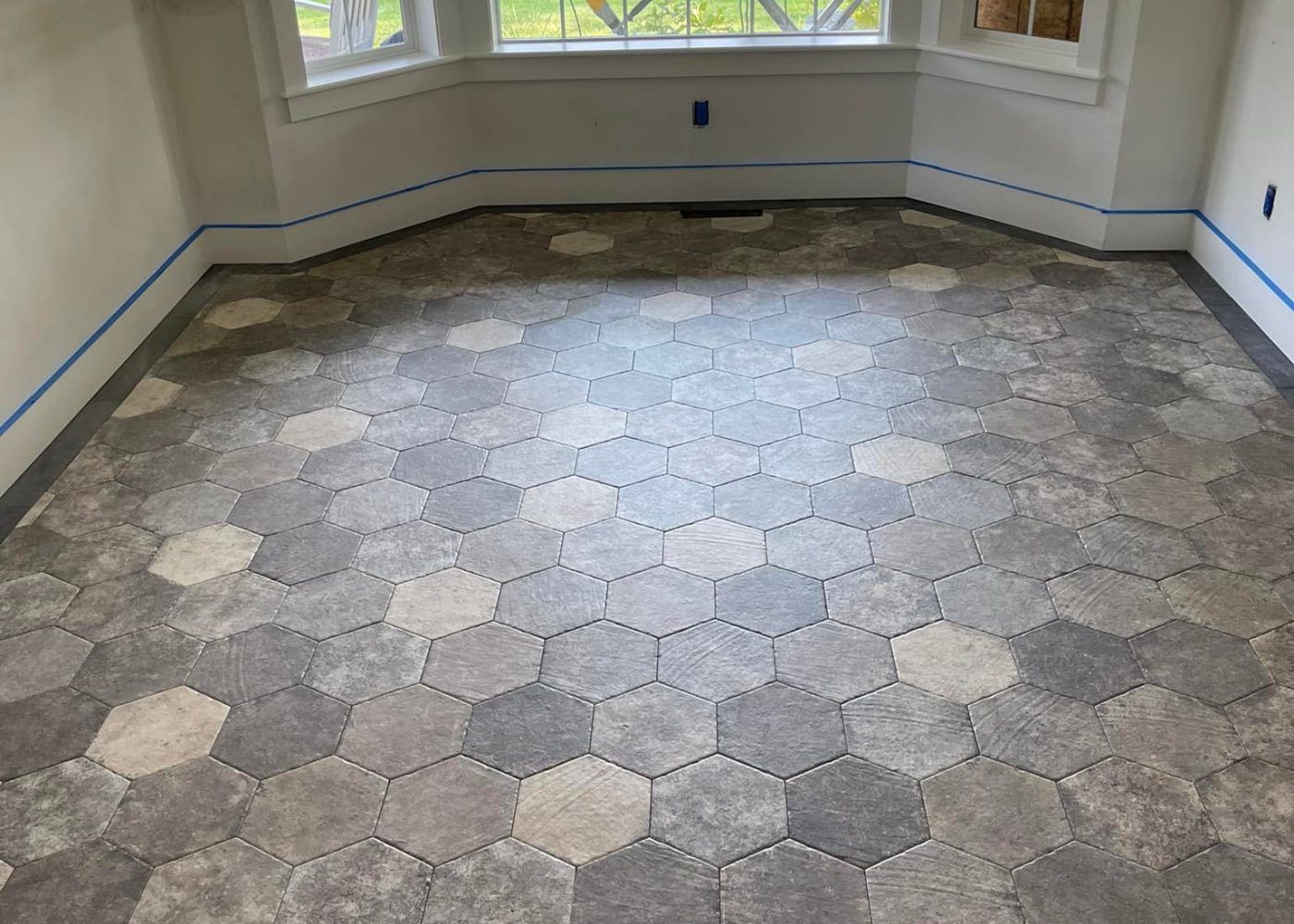 A room with a hexagonal tile floor and a window.