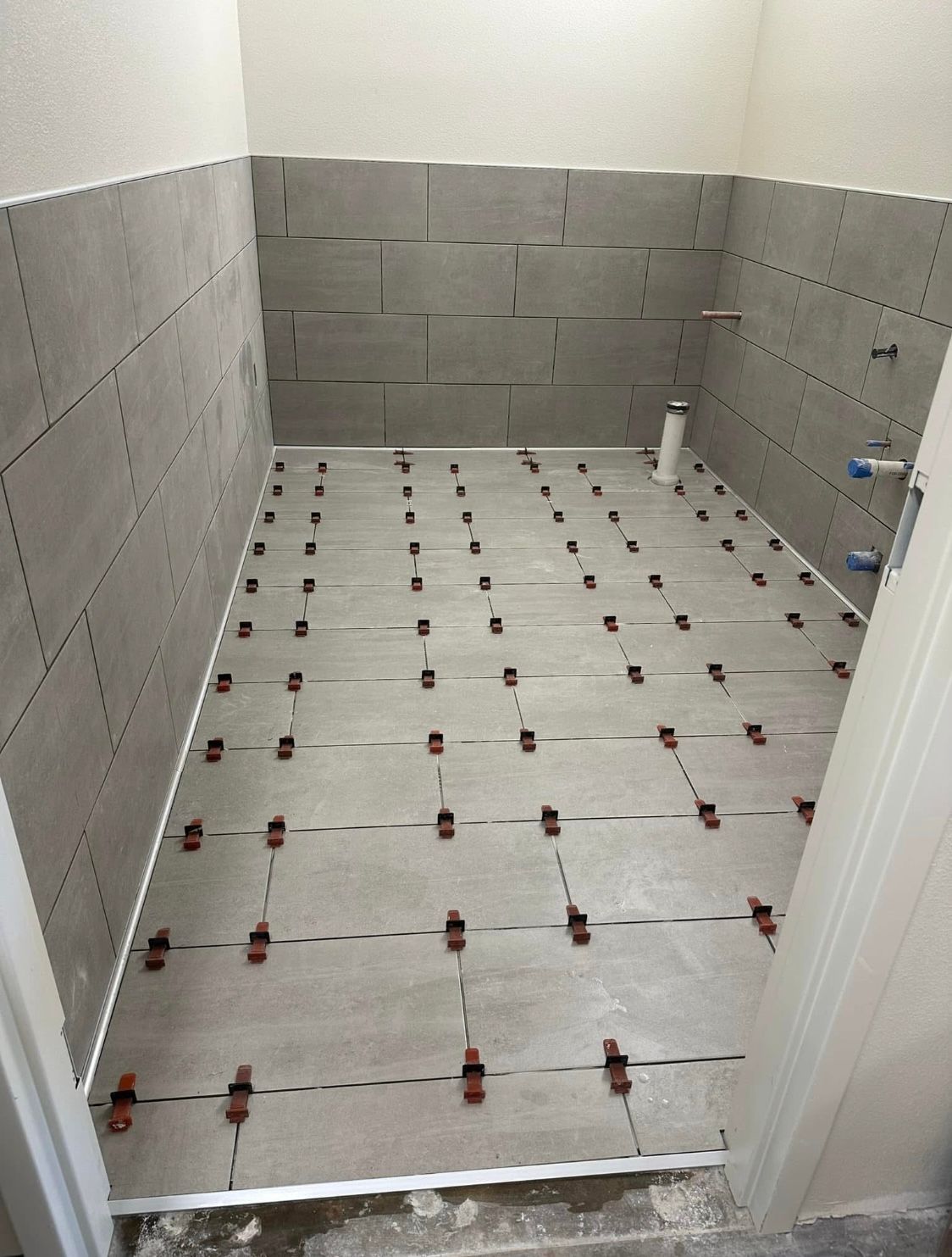 A bathroom with tiles on the floor and walls