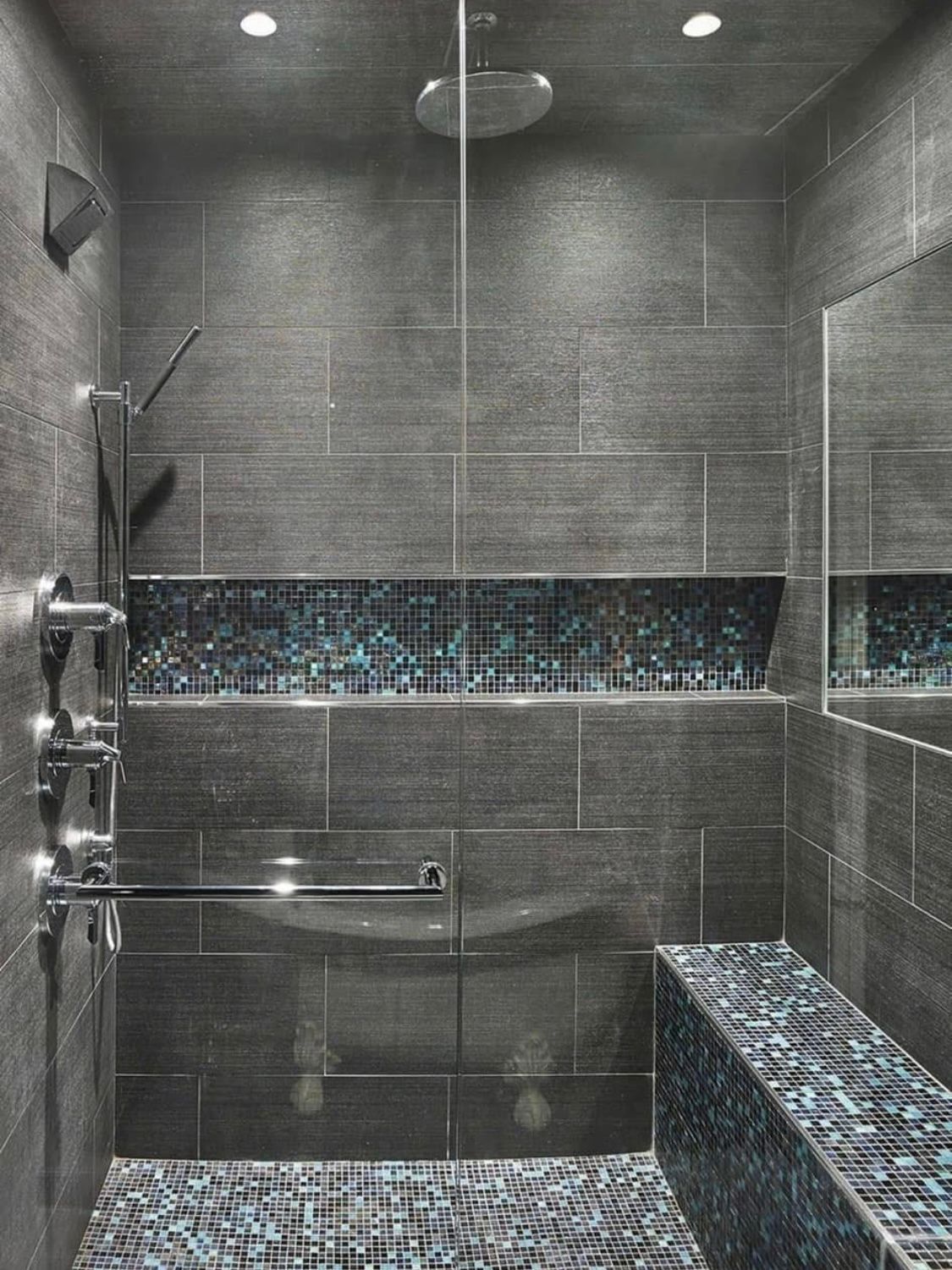 A bathroom with a walk in shower and a bench.