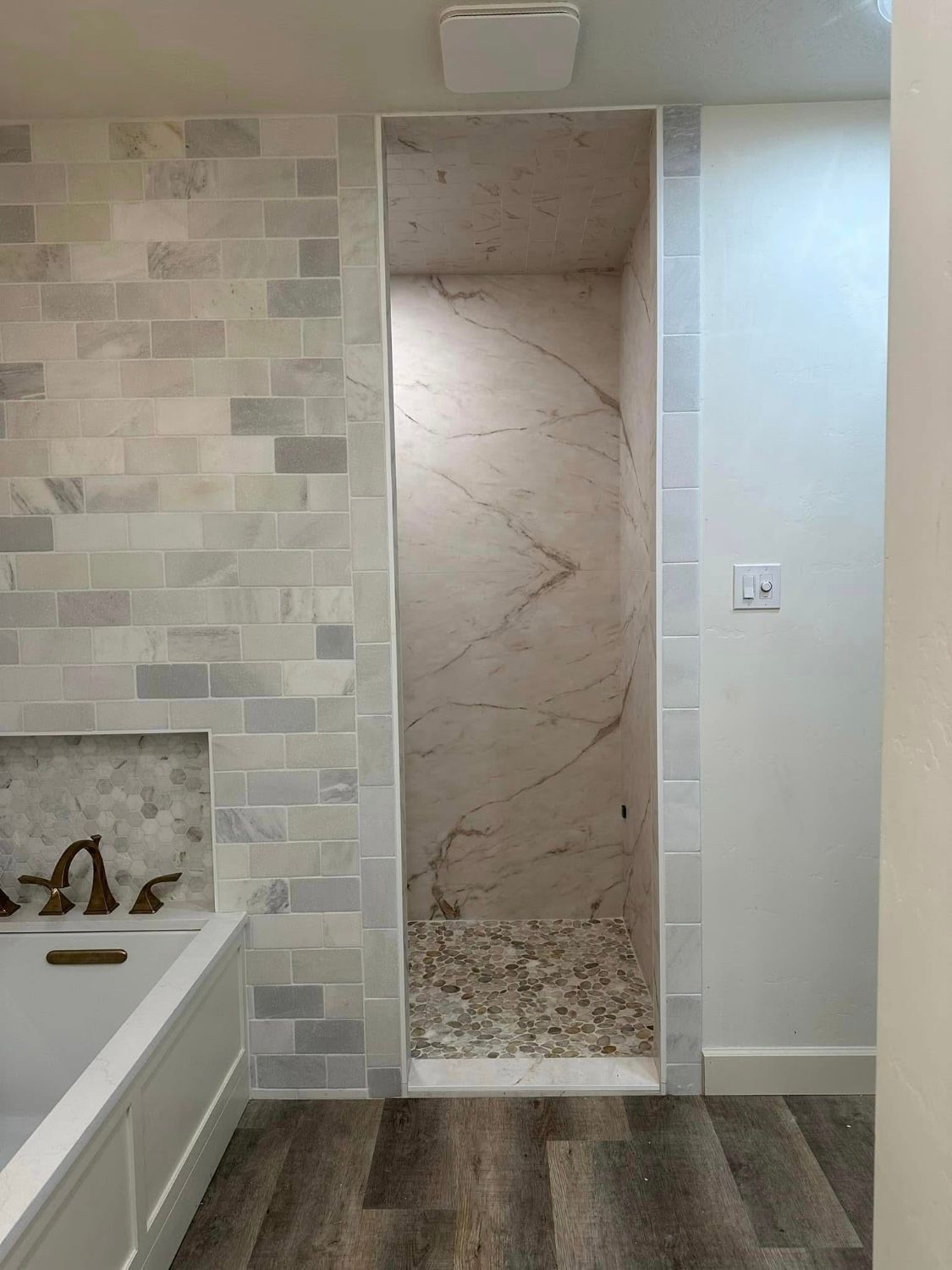 A bathroom with a bathtub and a walk in shower.