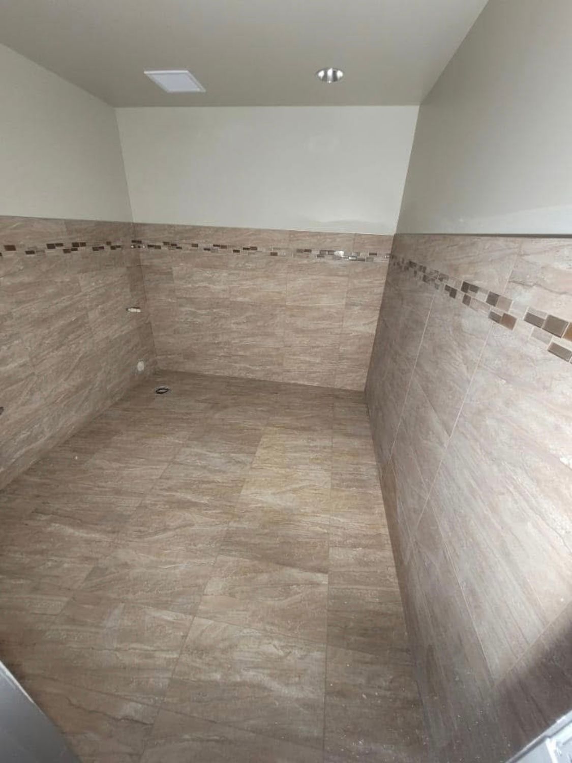A bathroom with a tiled floor and walls.