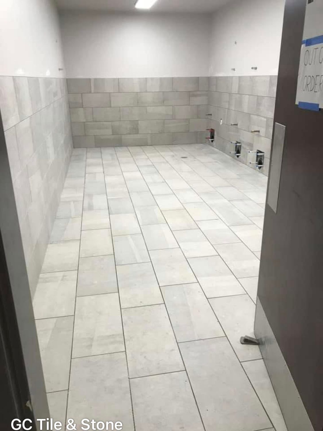 A room with white tiles on the floor and walls.