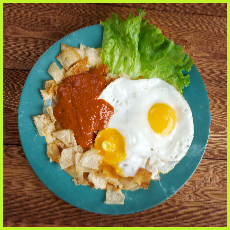 Eggs with tortilla chips topped with red sauce