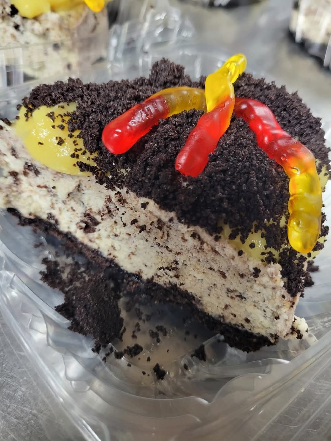 A slice of cake with gummy worms on top