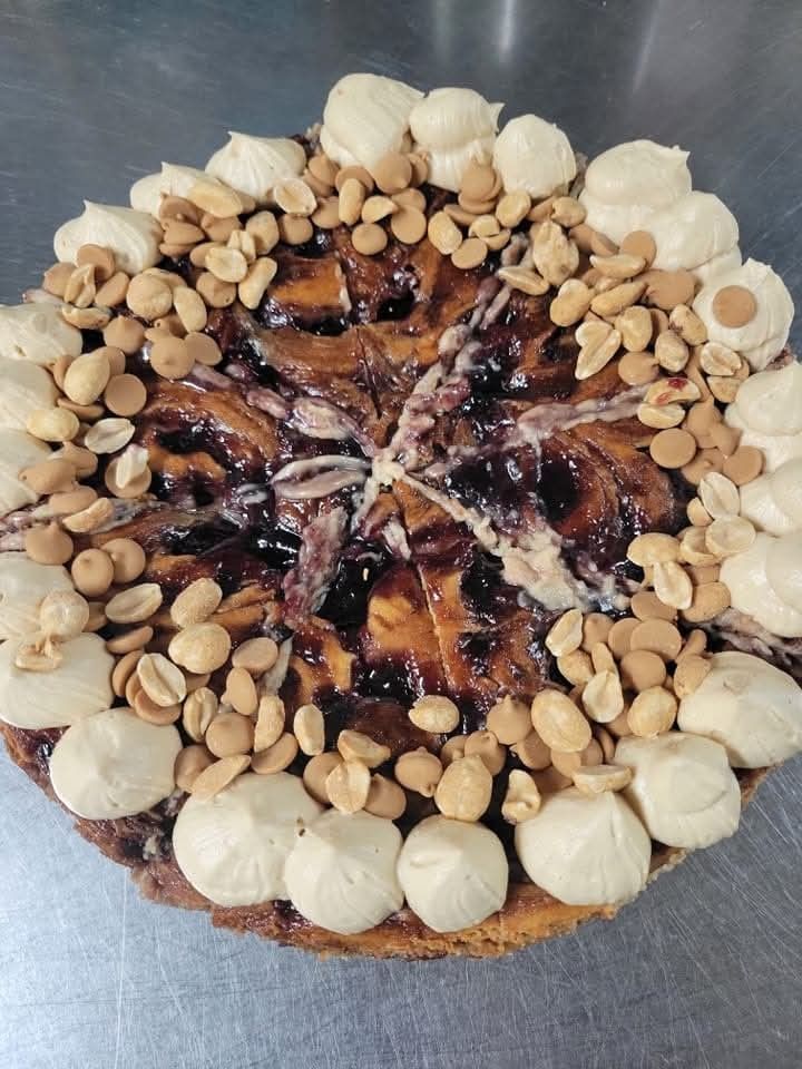 A pie with peanut butter frosting and nuts on top