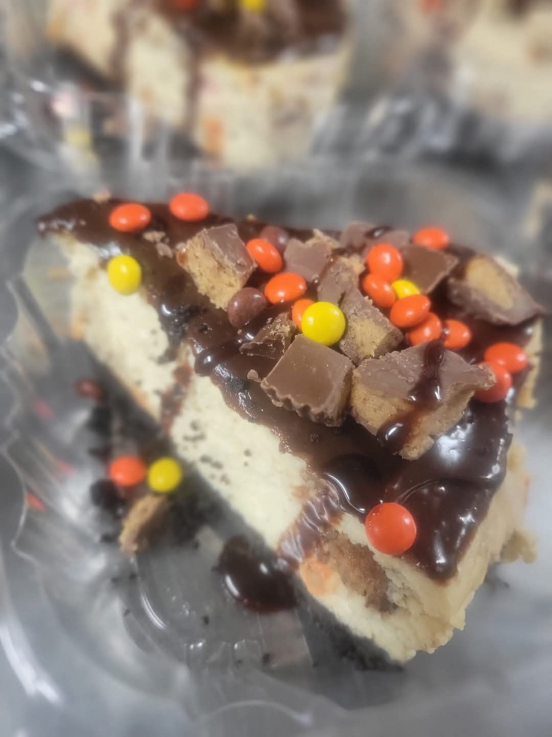 A slice of cheesecake with peanut butter cups on top