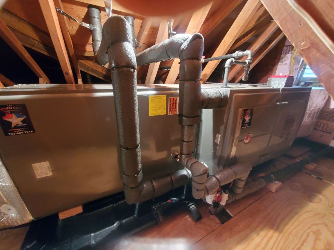 An air conditioner is sitting in the attic of a house.