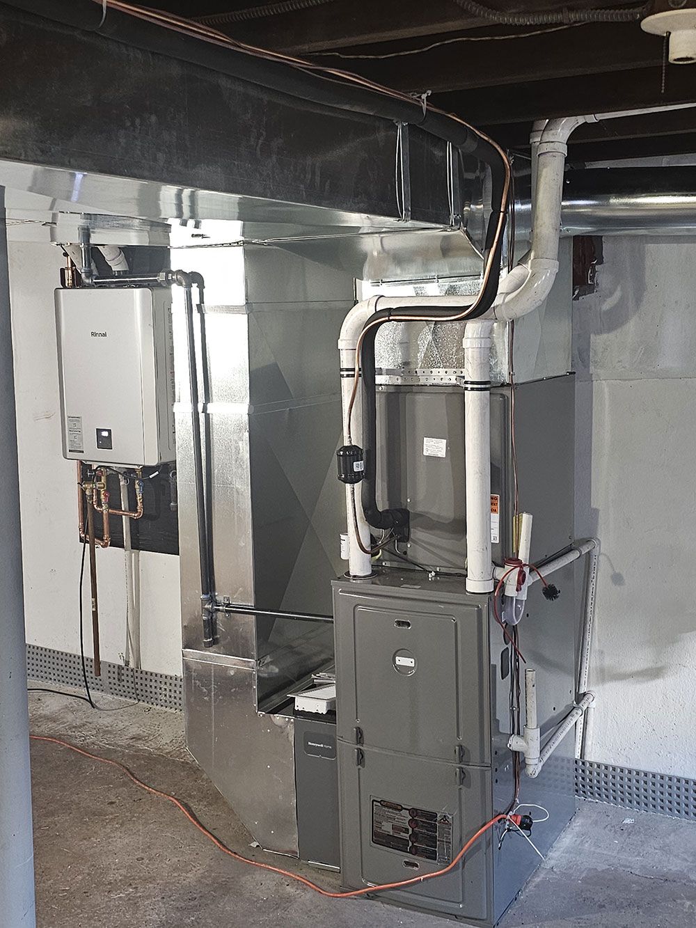 A basement with a furnace and a water heater.