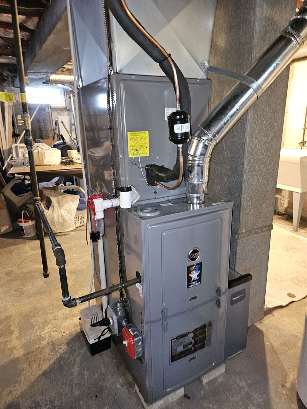 A gray furnace is sitting in the corner of a room.
