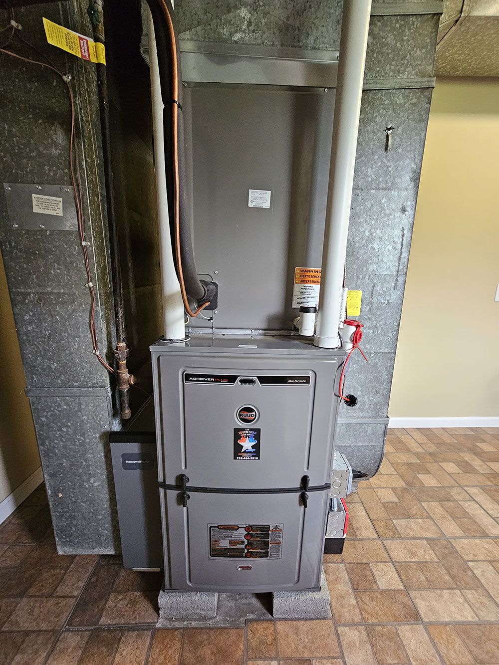 A furnace is sitting in a room next to a wall.
