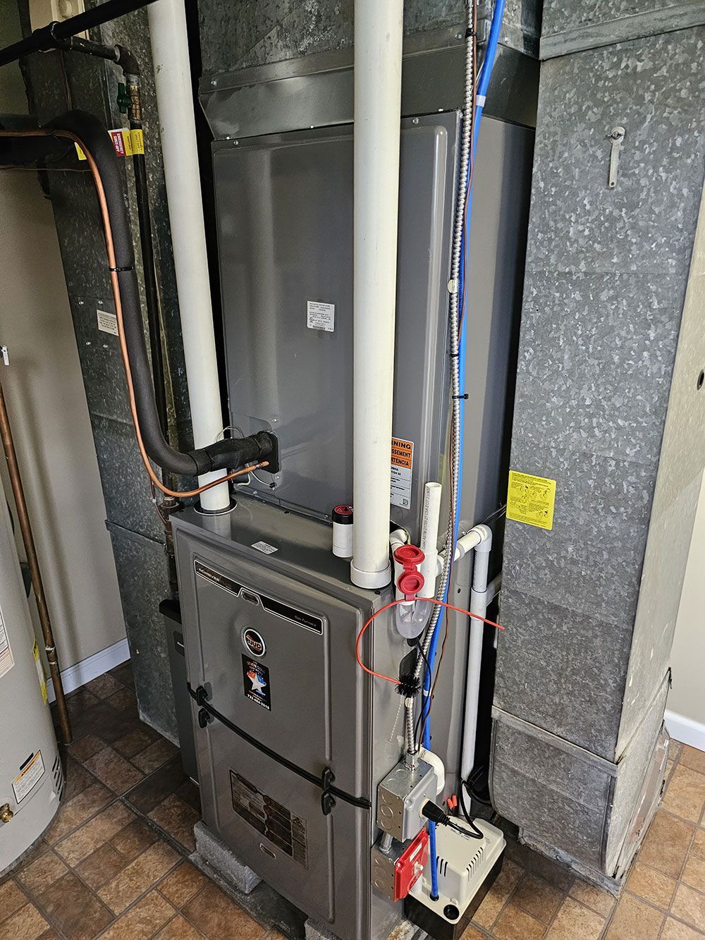 A furnace is sitting in a room next to a wall.