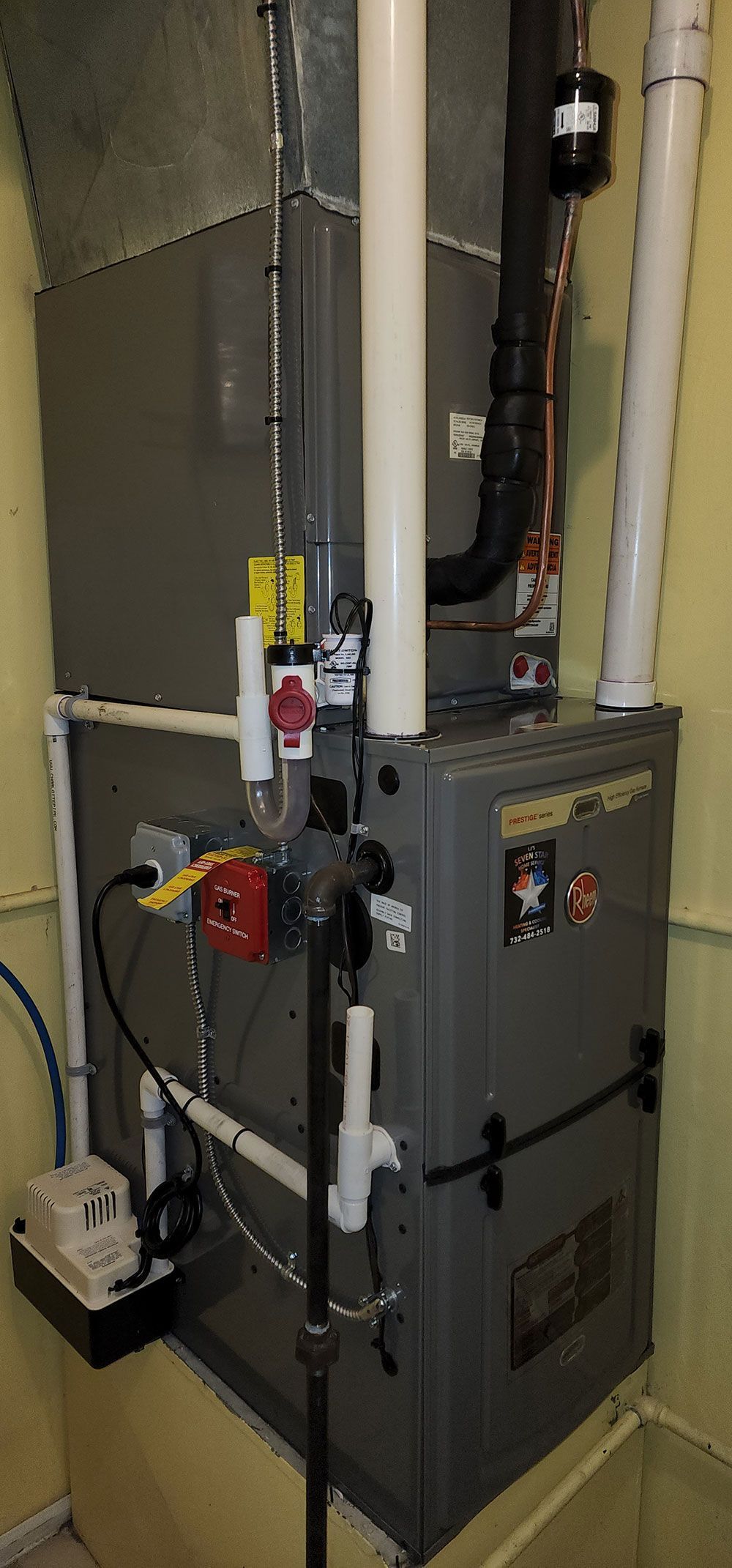 A furnace is sitting in a room next to a wall.