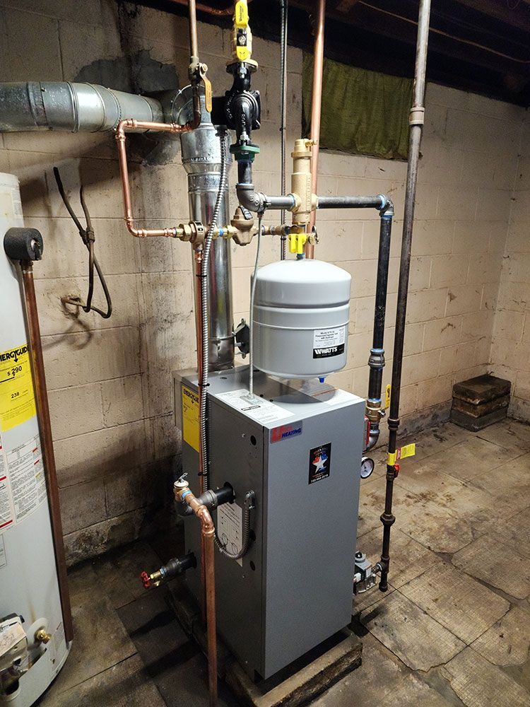 A gas water heater is sitting in a basement next to a water heater.