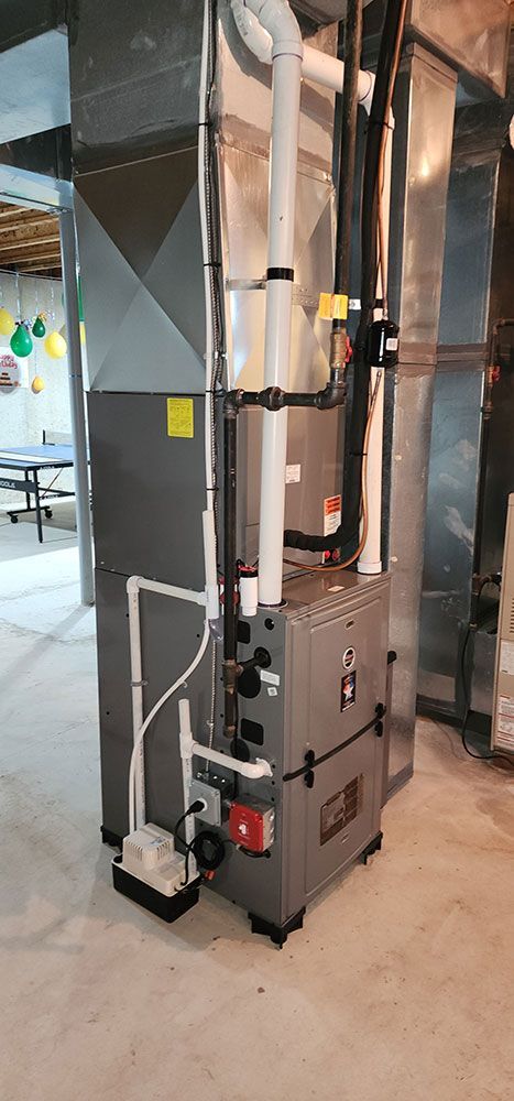 A furnace is sitting in the middle of a room in a basement.