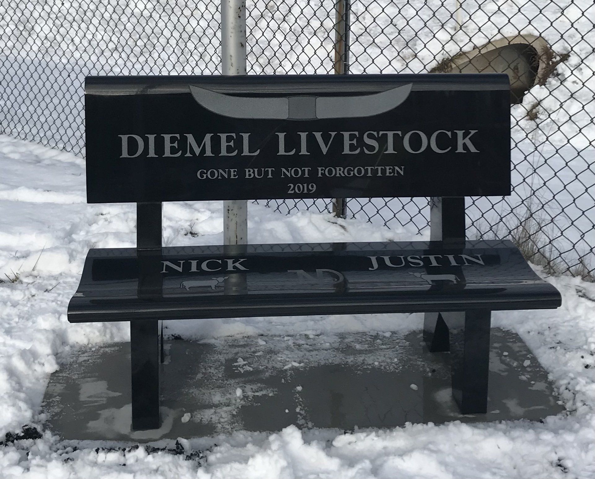 Black memorial bench with inscription 