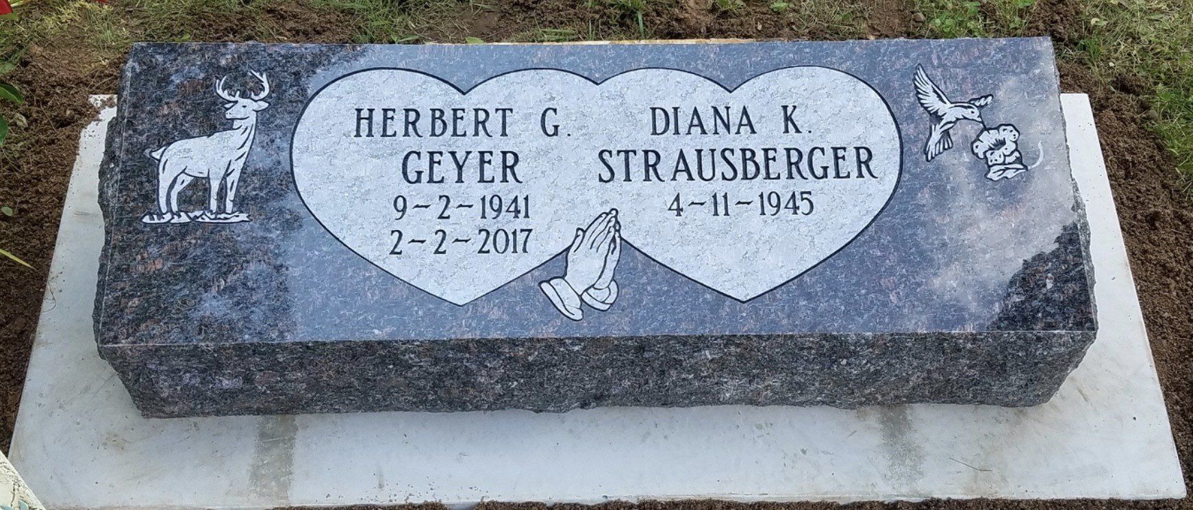 Headstone for Herbert G. Geyer and Diana K. Strausberger. Gray stone with deer and angel designs, inside heart shapes.