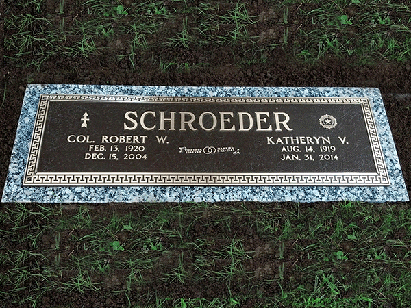 Bronze headstone for Robert and Katheryn Schroeder, set in earth. Dates and names engraved.