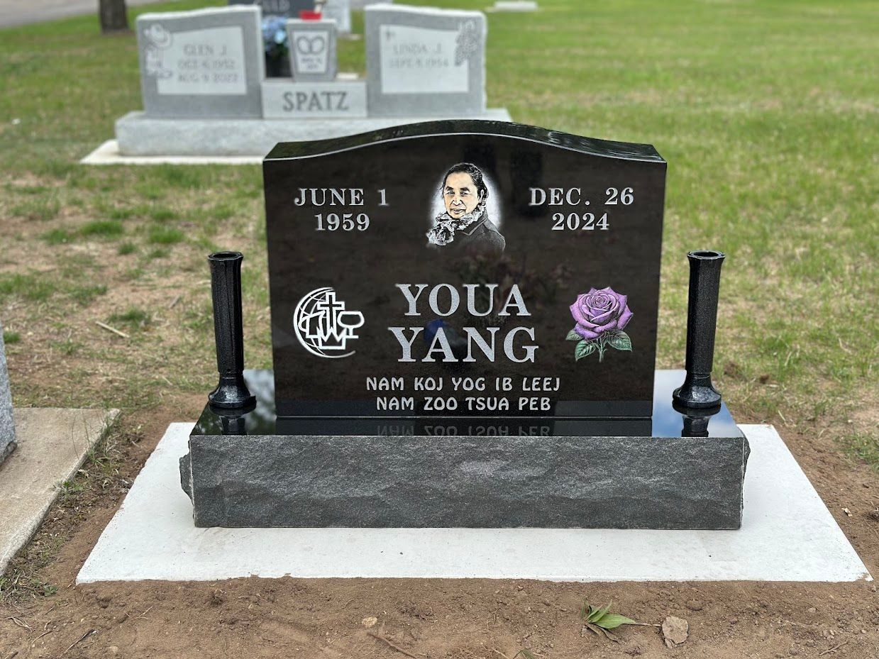 Black granite tombstone with a picture of Youa Yang, dates 1958-2021, and a purple flower.