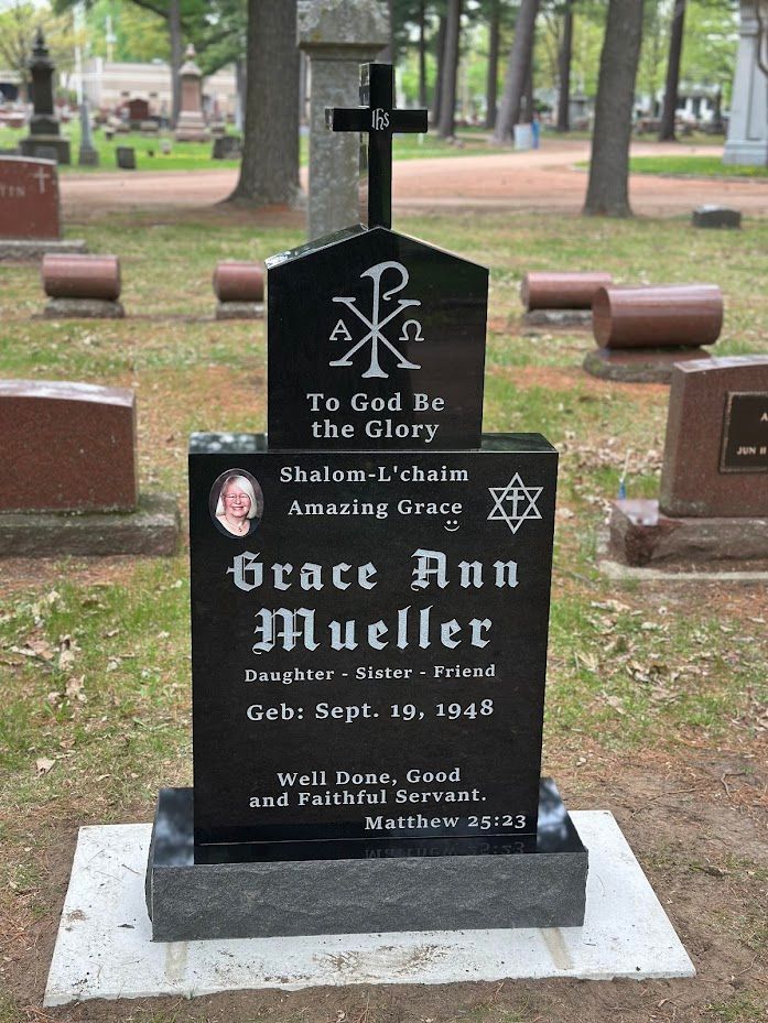 Black granite headstone with cross and text: 
