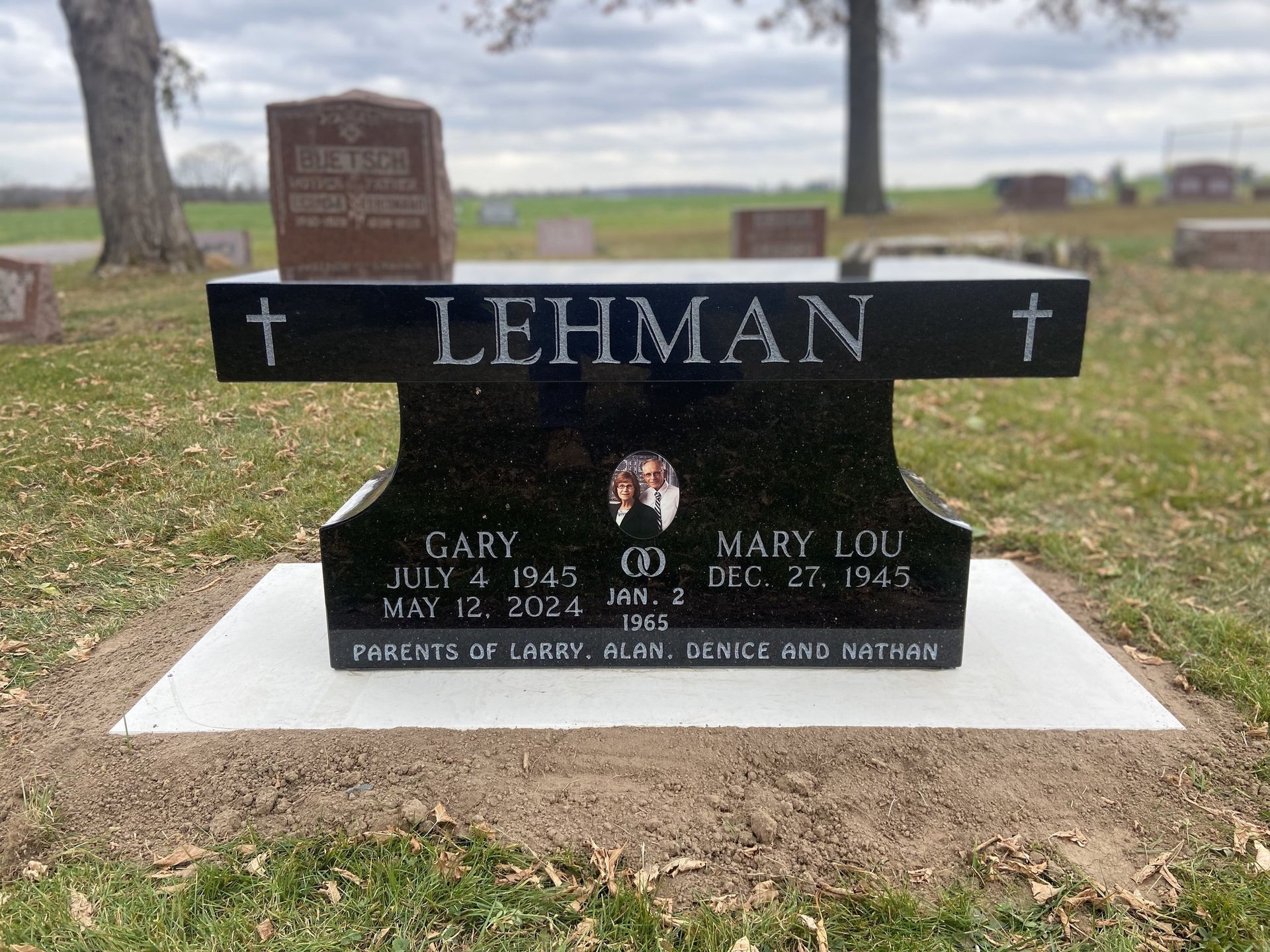 Black granite headstone with names LEHMAN, Gary and Mary Lou. Dates of birth and death inscribed. Two crosses.