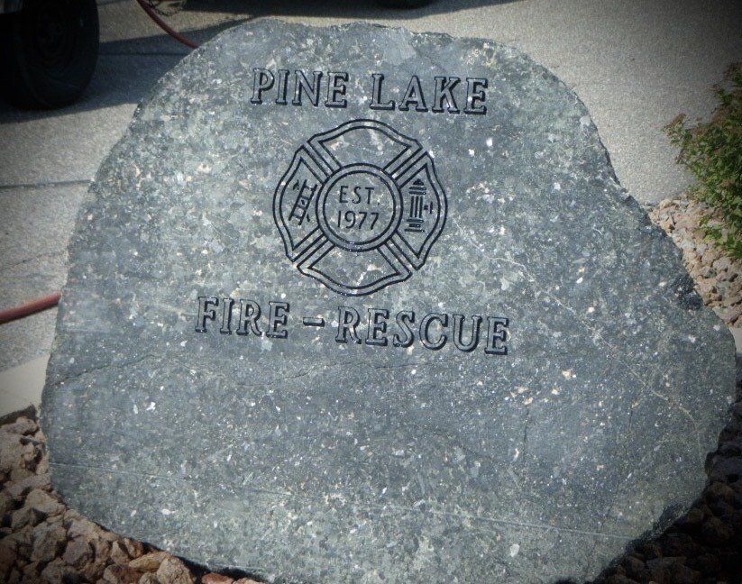 Pine Lake Fire-Rescue memorial stone with emblem and text 
