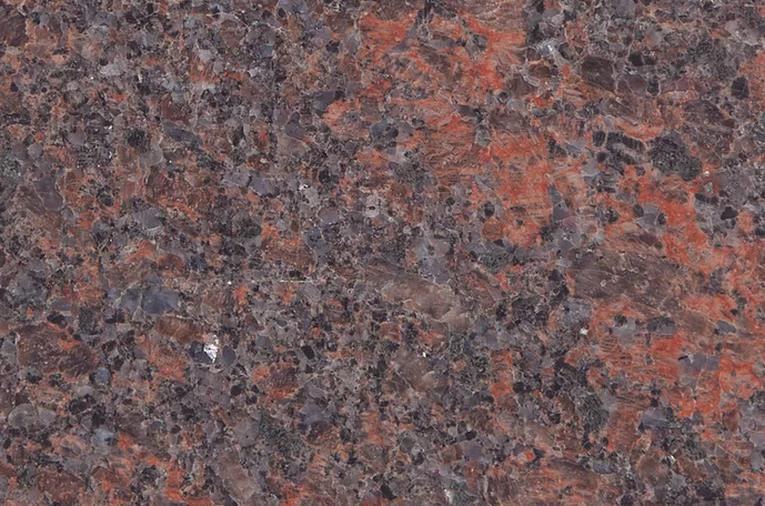 Red and black granite countertop with speckled pattern.