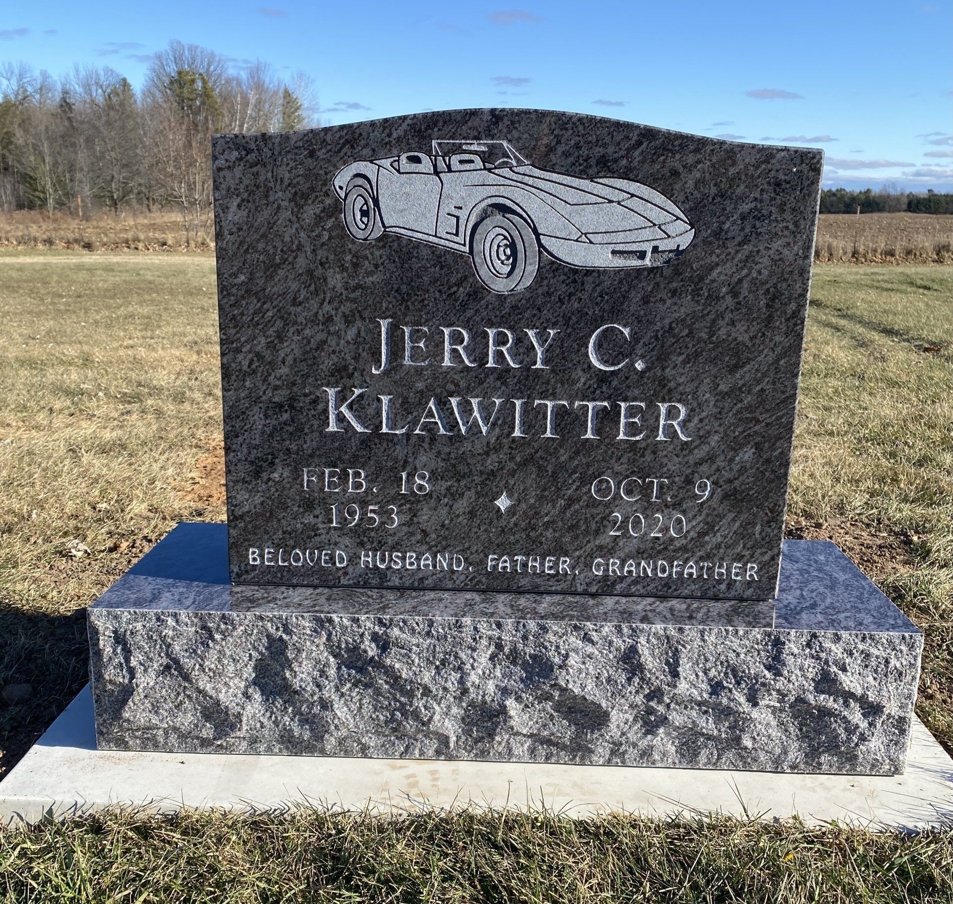 Gravestone of Jerry C. Klawitter, with a car design on top, dates 1953-2020.