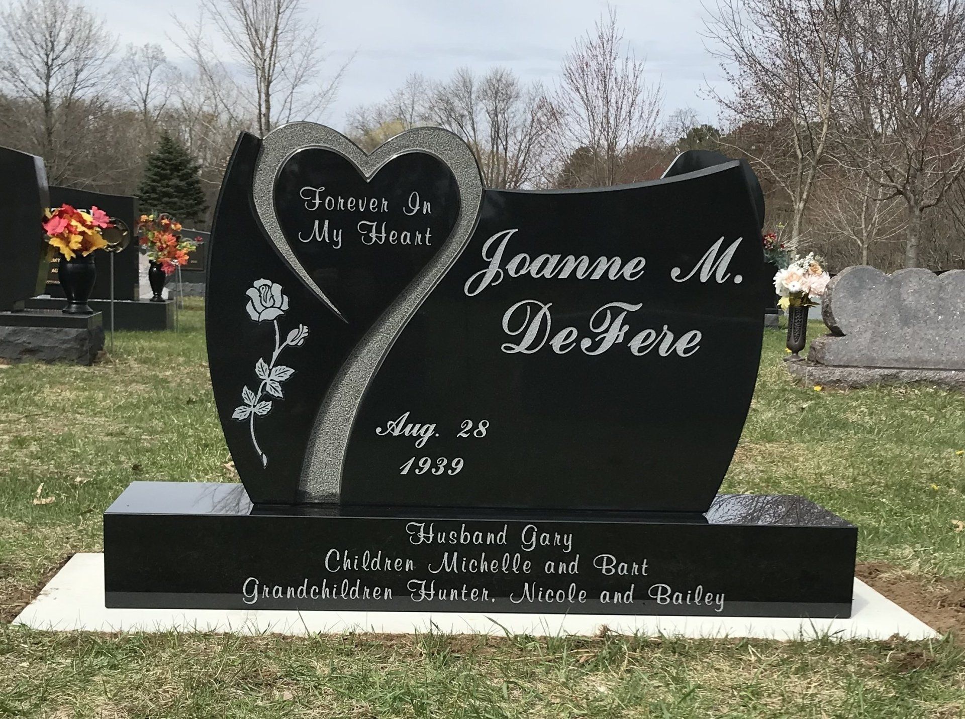 Black granite gravestone with heart design, name 