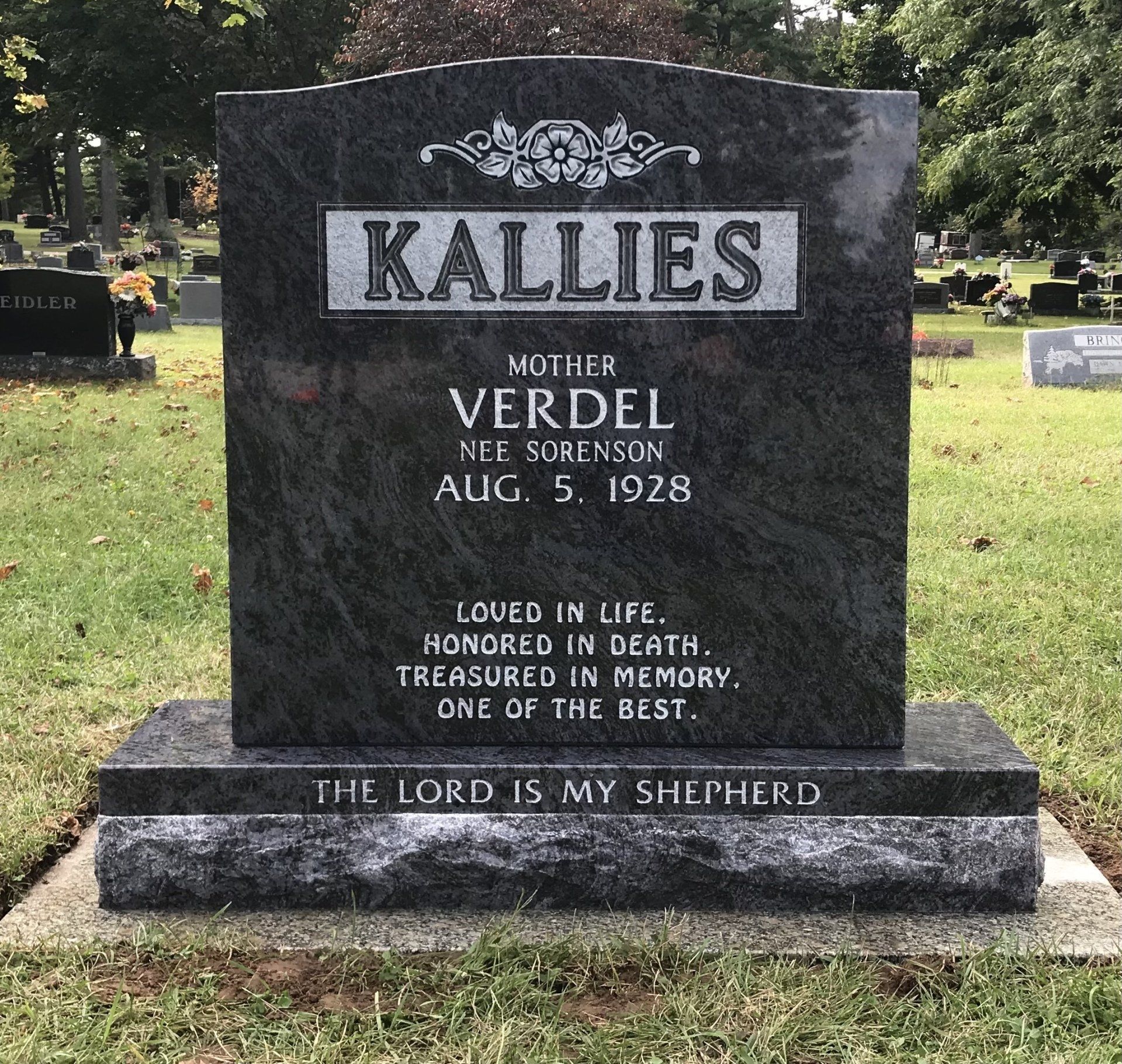 Dark granite headstone with the name Kallies and inscription 