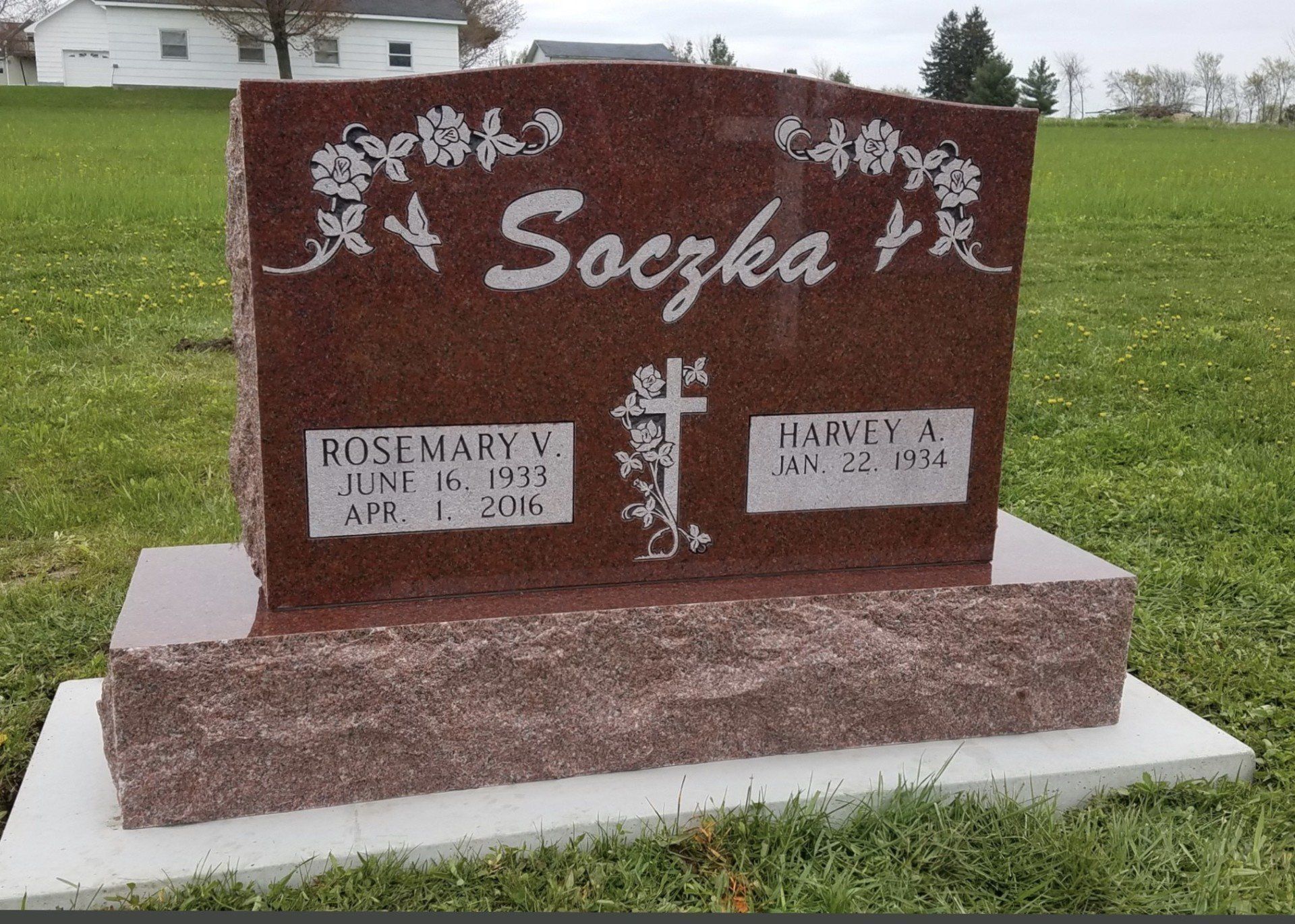 Red granite headstone for Soczka family, featuring names, dates, and a cross symbol.