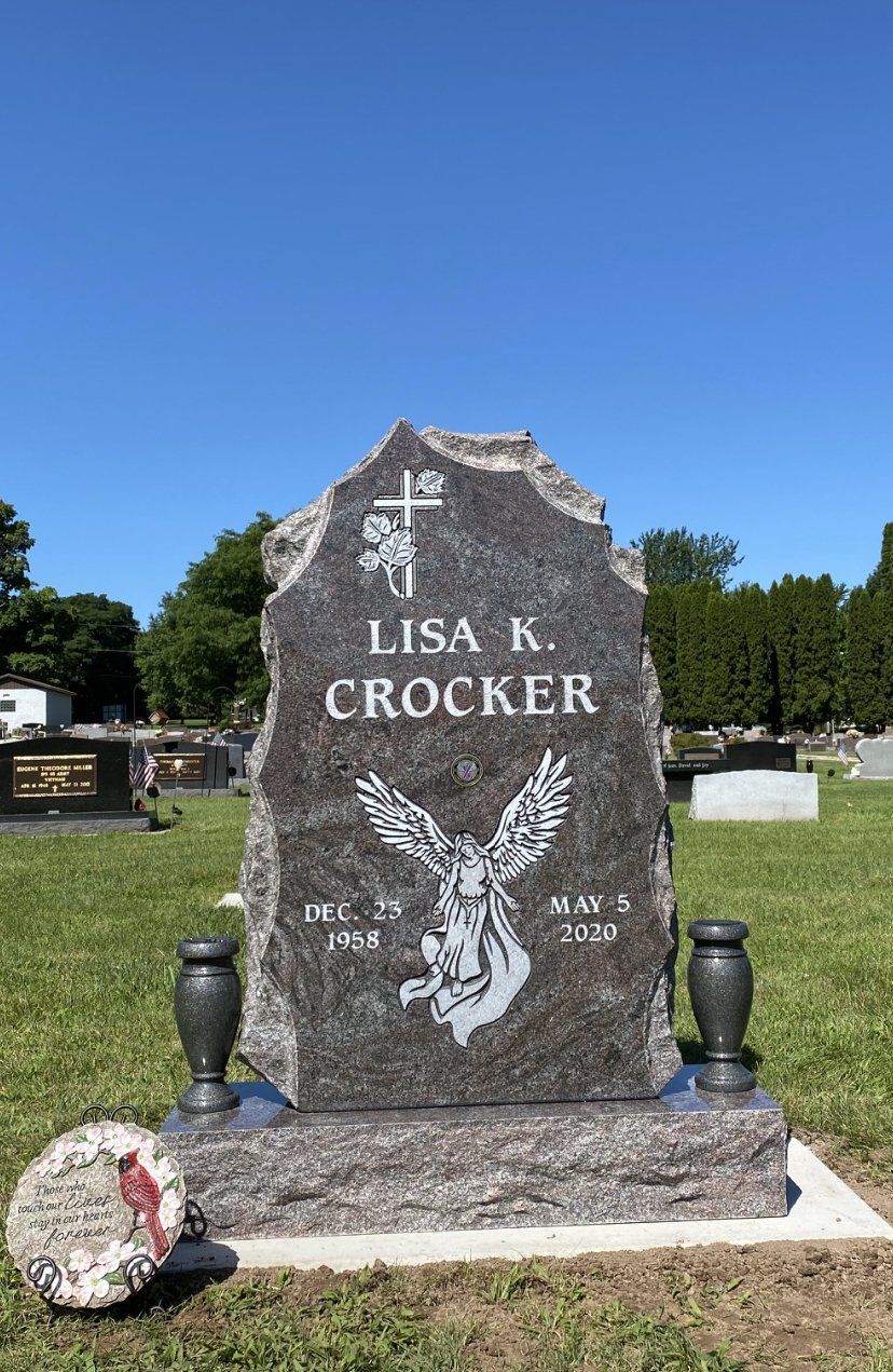 Gravestone of Lisa K. Crocker, with an eagle carving, in a cemetery, with date of birth and death.