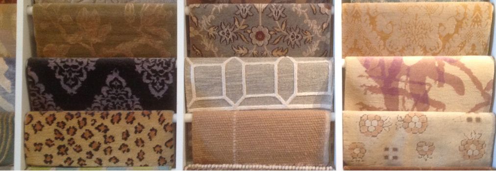 A variety of carpets are displayed on a shelf.