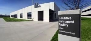 A modern building with a sign that reads Sensitive Instrument Facility under the US Department of Energy.