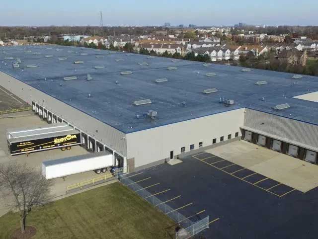 Large industrial warehouse with loading docks, semi-truck.