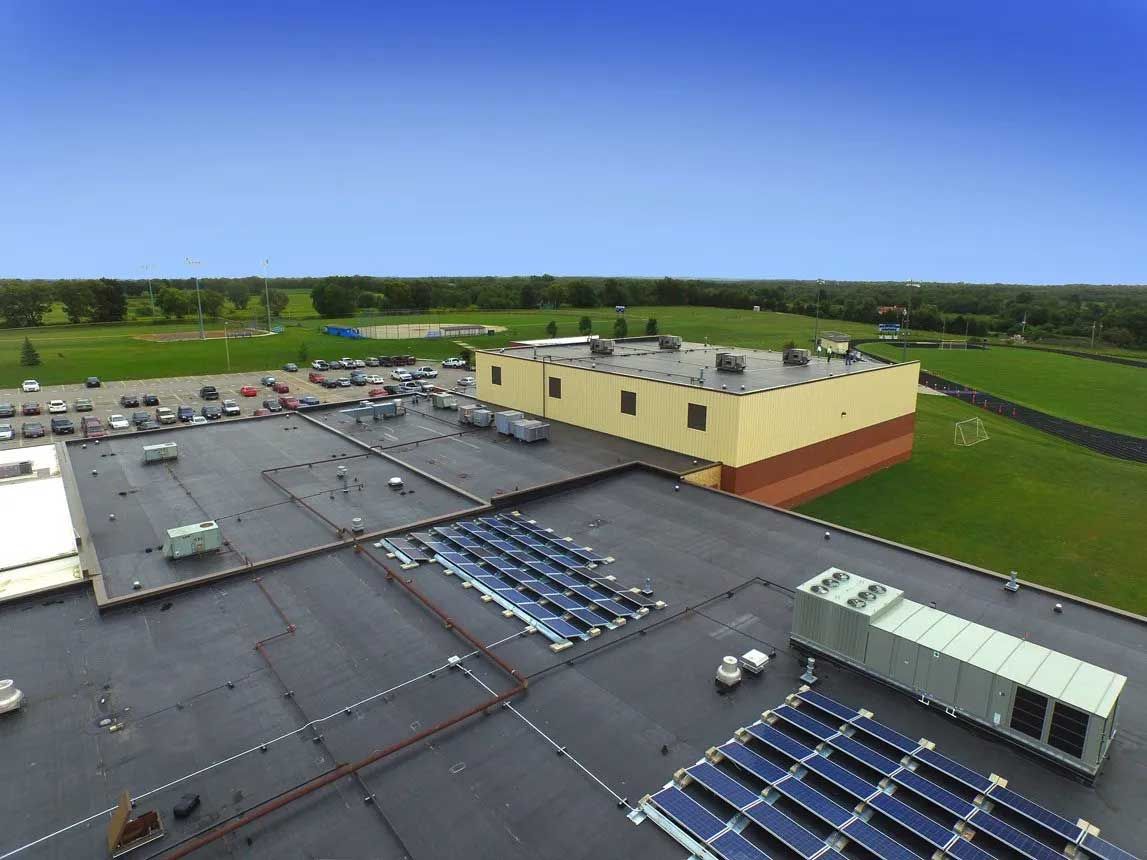 Aerial view of a building roof with solar panels.