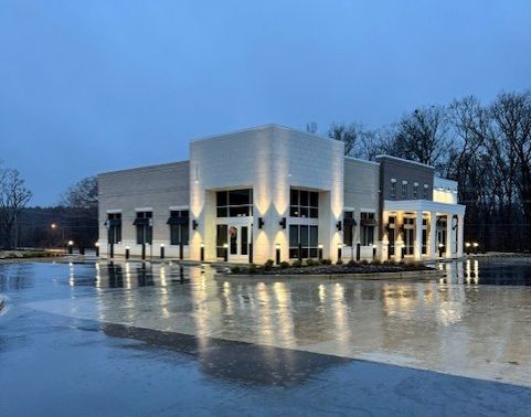 A large white building with a lot of windows is lit up at night.