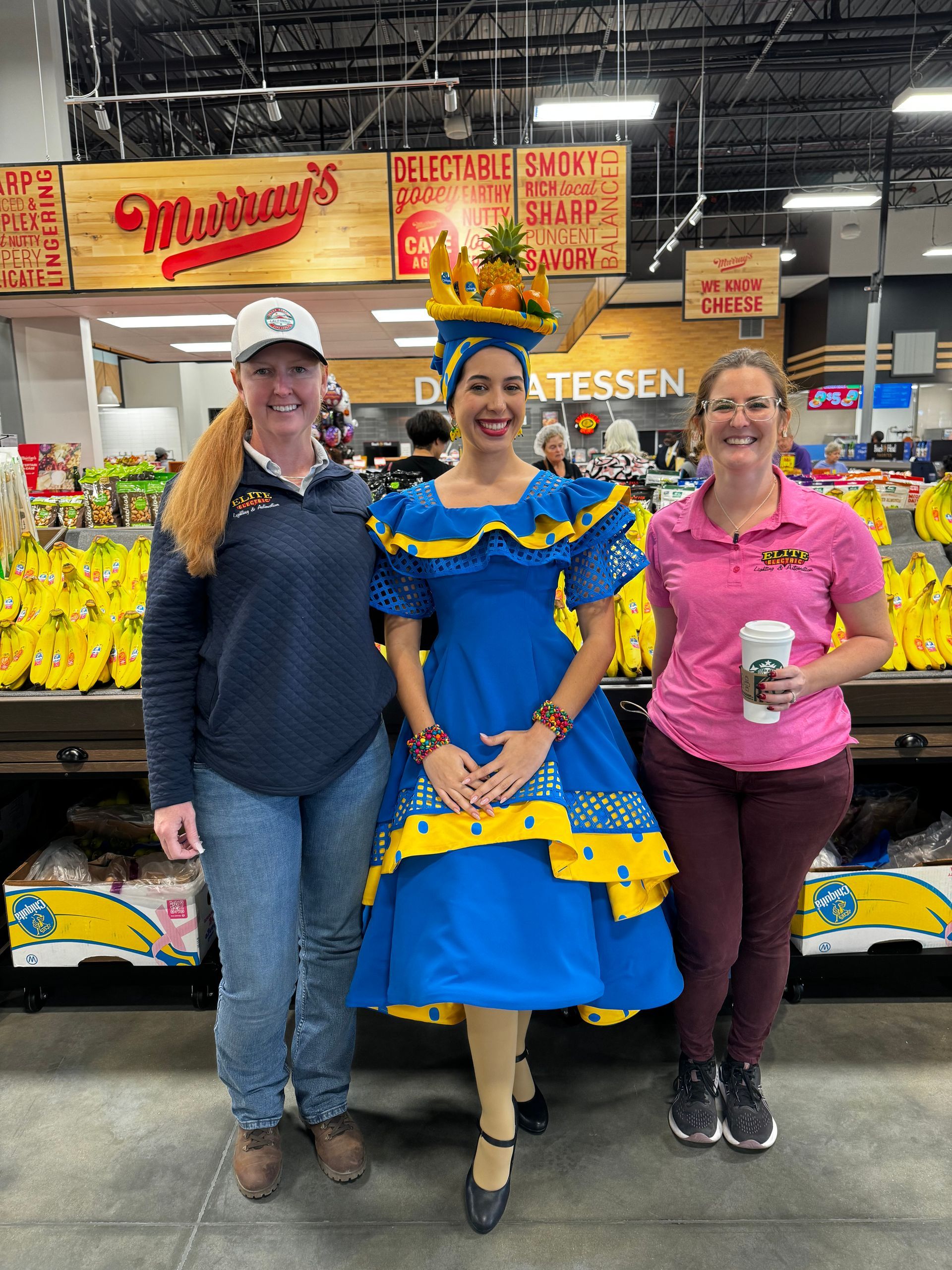 Three women are posing for a picture in a grocery store