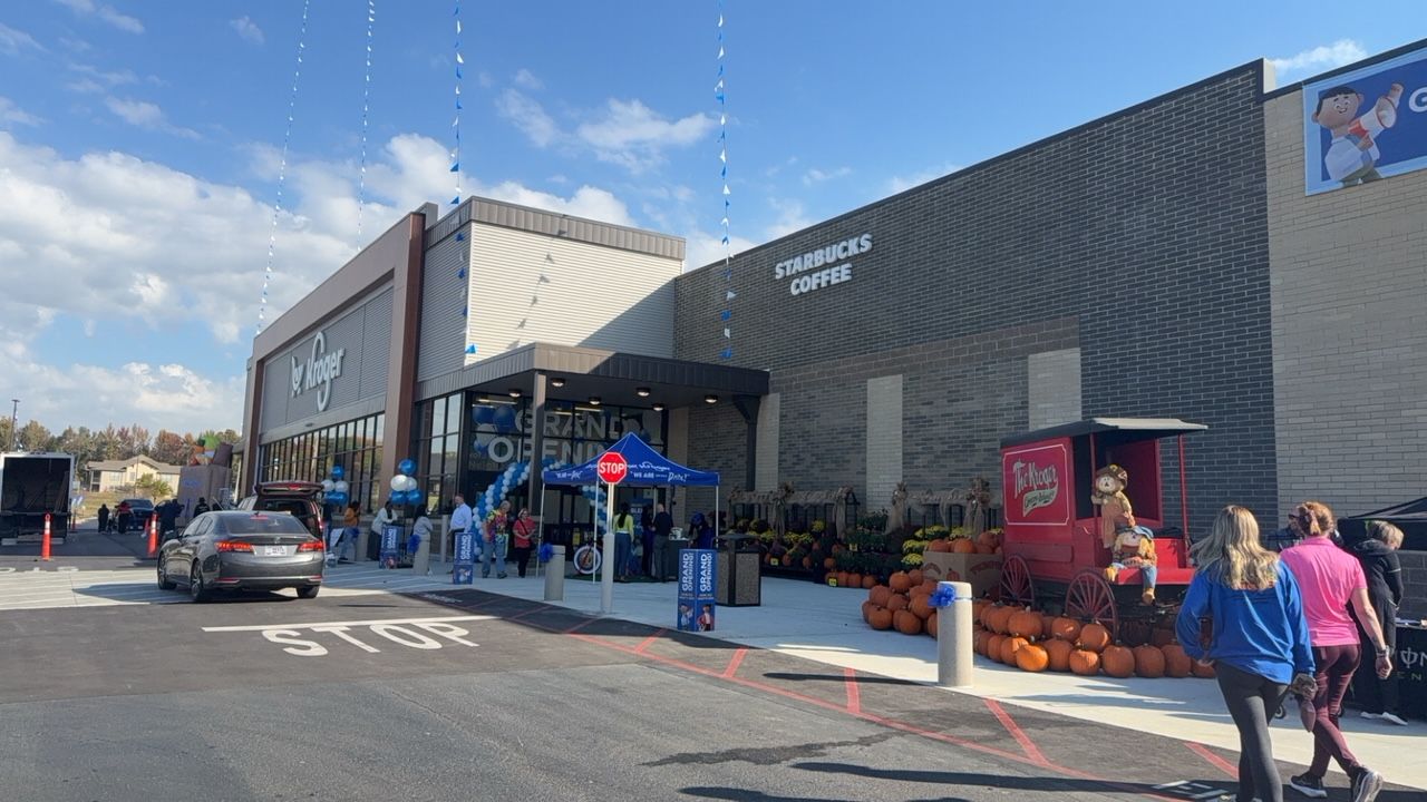 A group of people are walking in front of a large building.