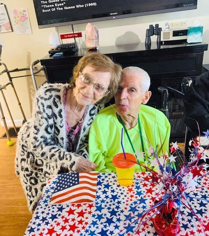 Two people seated at a table with star-spangled decorations and an American flag centerpiece