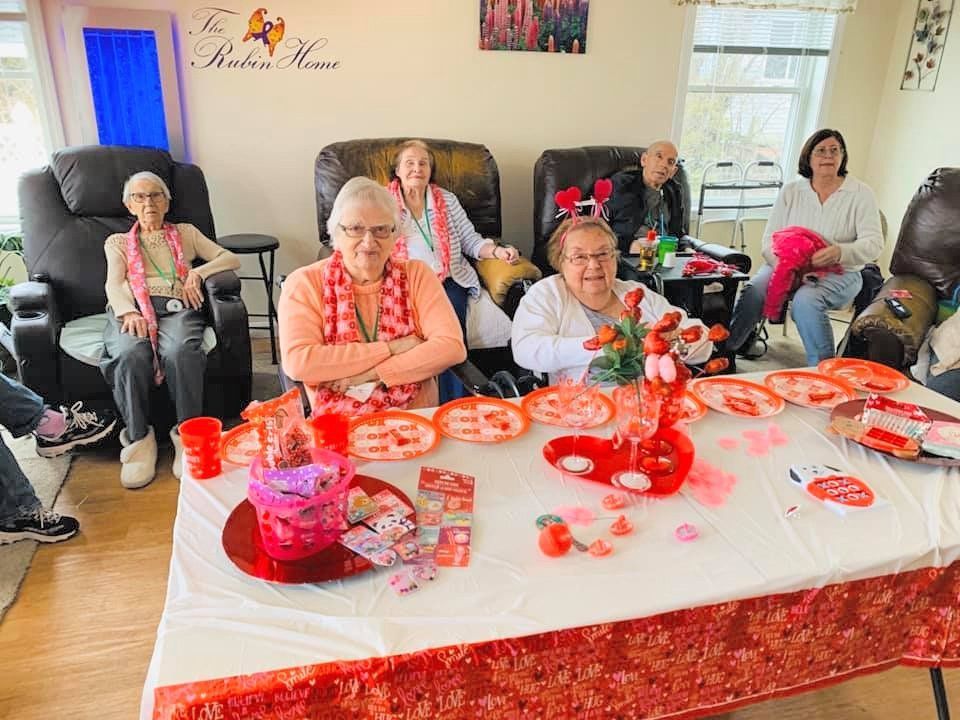 People seated around a red-and-white decorated table at a festive indoor gathering